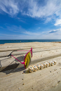 Deck chairs on beach against blue sky