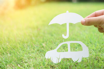 Person holding umbrella on field