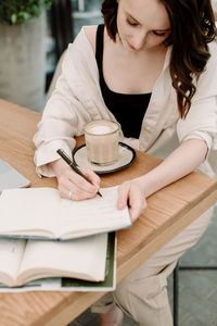 Young woman holding coffee cup on table