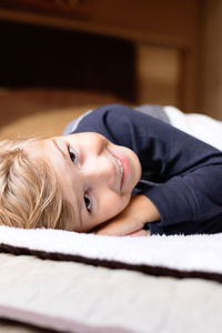 Portrait of boy lying on bed at home