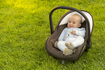 Cute baby girl lying on grassy field