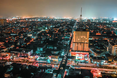 High angle view of city lit up at night