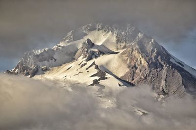 Scenic view of mt hood covered against cloudy sky