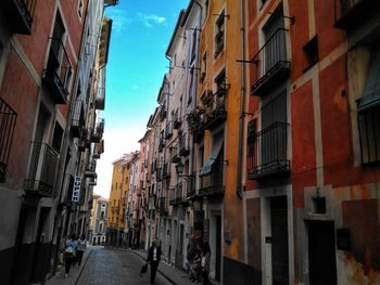 People walking on street in city against sky