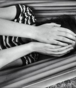 High angle view of woman covering face while lying in hammock