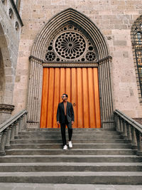 Full length of man standing on staircase outside building