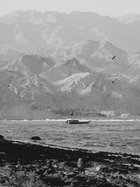 Scenic view of sea and mountains against sky