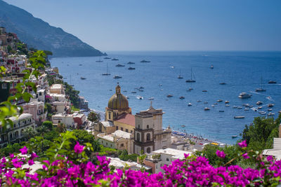 High angle view of townscape by sea against clear sky