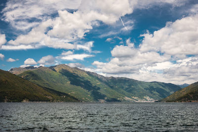 Scenic view of lake by mountains against sky