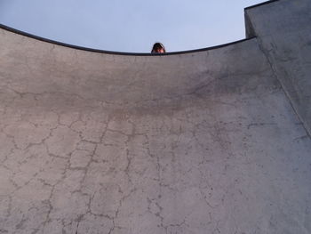 Rear view of person on wall against sky