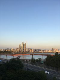 City at waterfront against clear blue sky