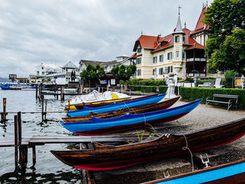 Boats moored at harbor against buildings in city