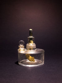 Close-up of oil lamp on table against black background
