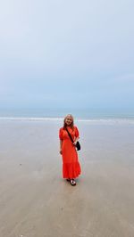 Rear view of woman photographing sea against clear sky