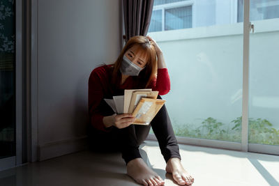 Full length of young woman sitting on table