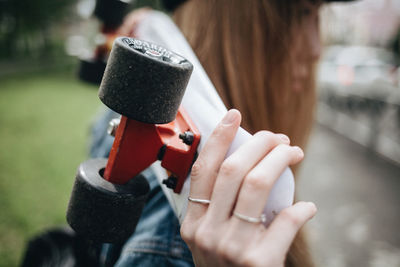 Close-up of woman holding skateboard