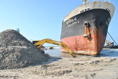 Boat on beach against clear sky