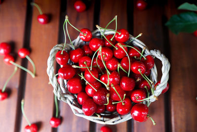 Fruit basket on a wooden table top view. harvest berries. summer background with ripe cherries.