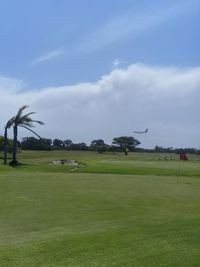 Scenic view of golf course against sky