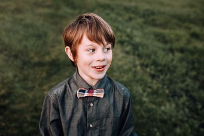 Smiling boy looking away while standing outdoors