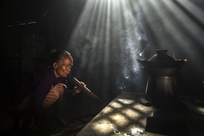 Rear view of man sitting on table