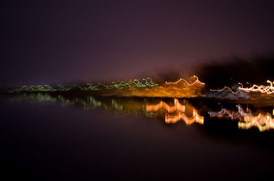 Scenic view of lake against sky at night