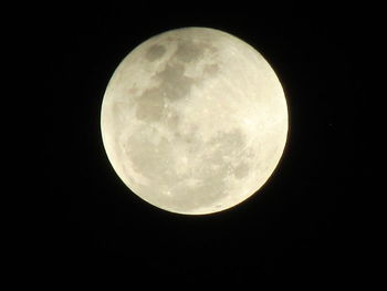 Low angle view of full moon against clear sky at night