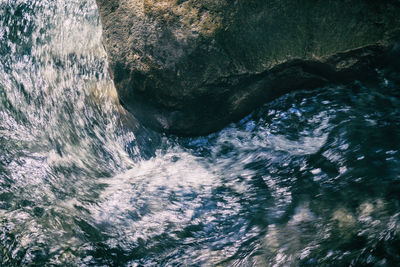 High angle view of water flowing through rocks