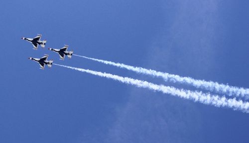 Low angle view of airplane flying against clear blue sky