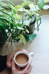 Hand holding coffee cup on table