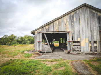 Abandoned house on field against sky