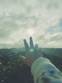 Person hand against sky