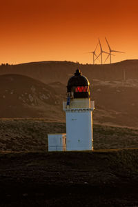 Built structure on land against sky during sunset