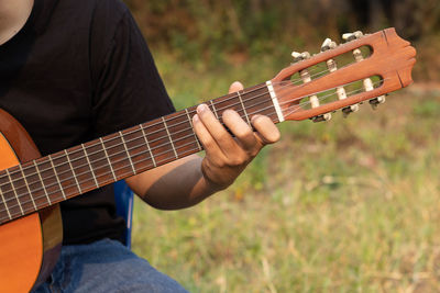 Midsection of man playing guitar