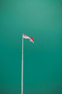 Low angle view of flag against blue sky