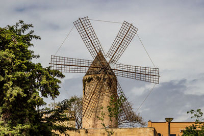 Low angle view of traditional windmill against sky