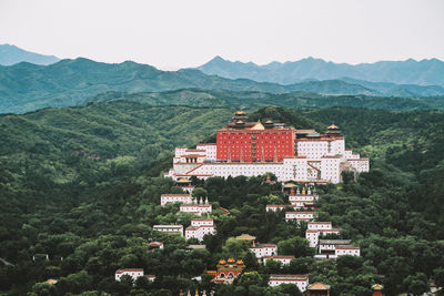 High angle view of townscape by mountain against sky