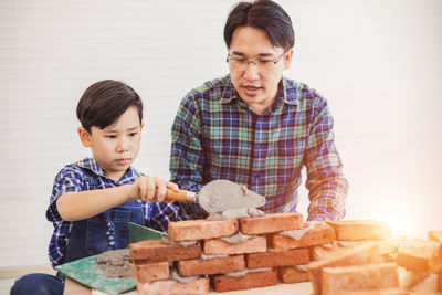 Father and son holding camera