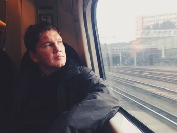 Man looking through window while travelling in train