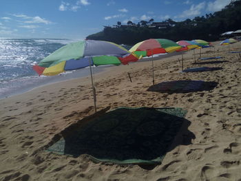 Multi colored umbrellas on beach against sky