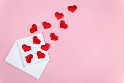 High angle view of heart shape over pink background