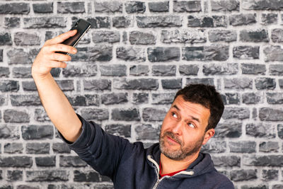 Portrait of man photographing against wall