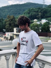 Full length of young man standing against railing