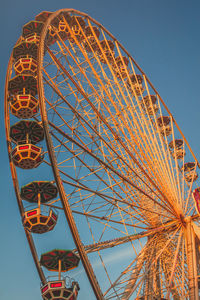 Low angle view of ferris wheel against clear blue sky