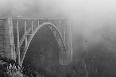 Arch bridge against sky during foggy weather