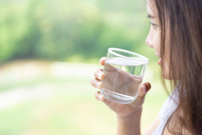 Portrait of a young woman drinking from glass