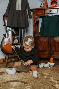 Cute little toddler baby girl in vintage clothes playing at home. gender-neutral baby fashion