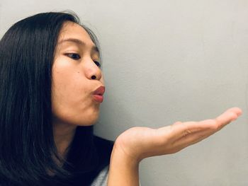 Portrait of a beautiful young woman against wall