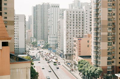 Traffic on street amidst buildings in city