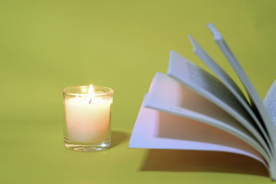 Close-up of lit candle on table